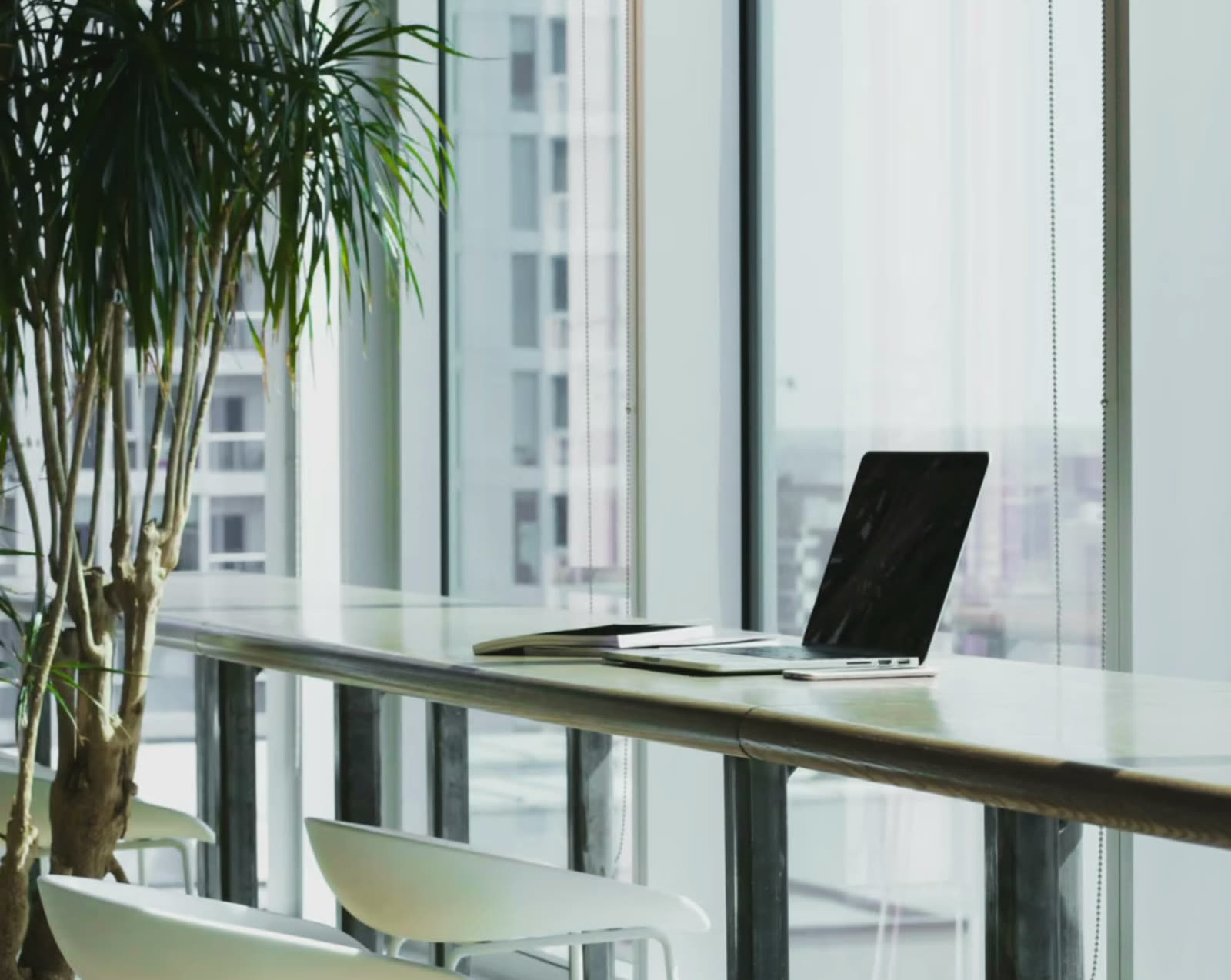 Bright workspace with a laptop by tall windows
